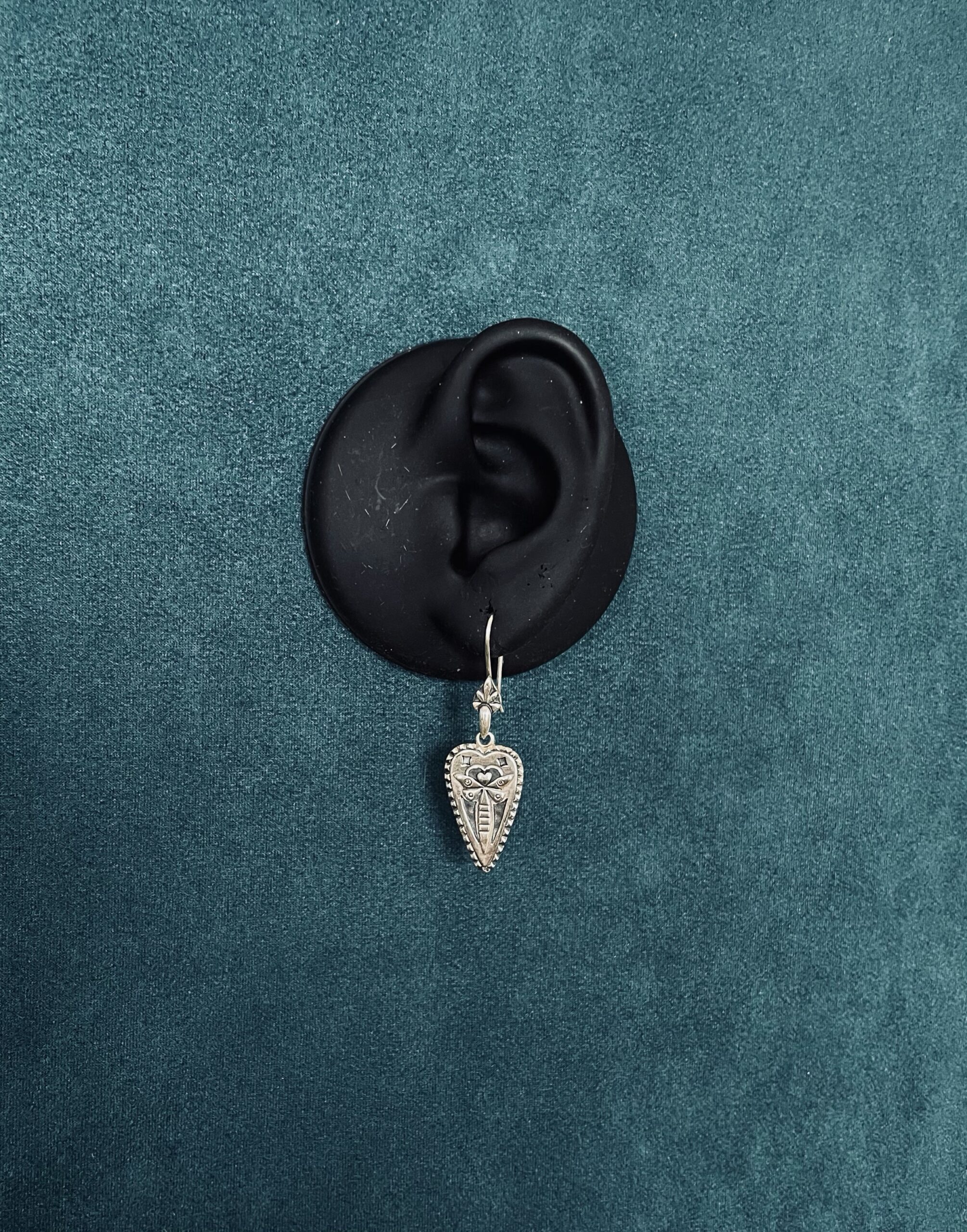 Mayfly earring on life size black ear